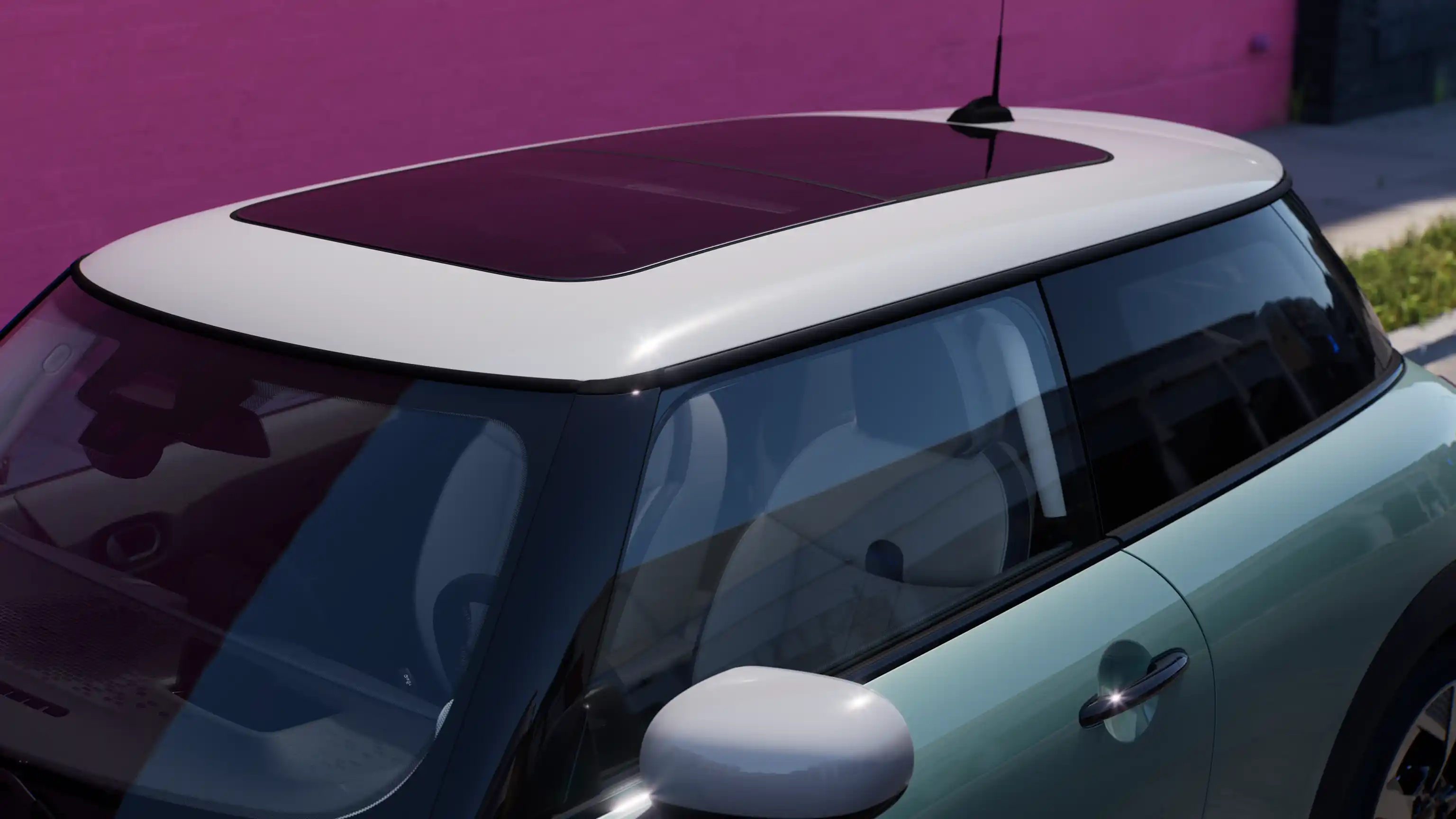 Vista desde arriba del MINI Cooper en Ocean Wave Green con techo panorámico en contraste.