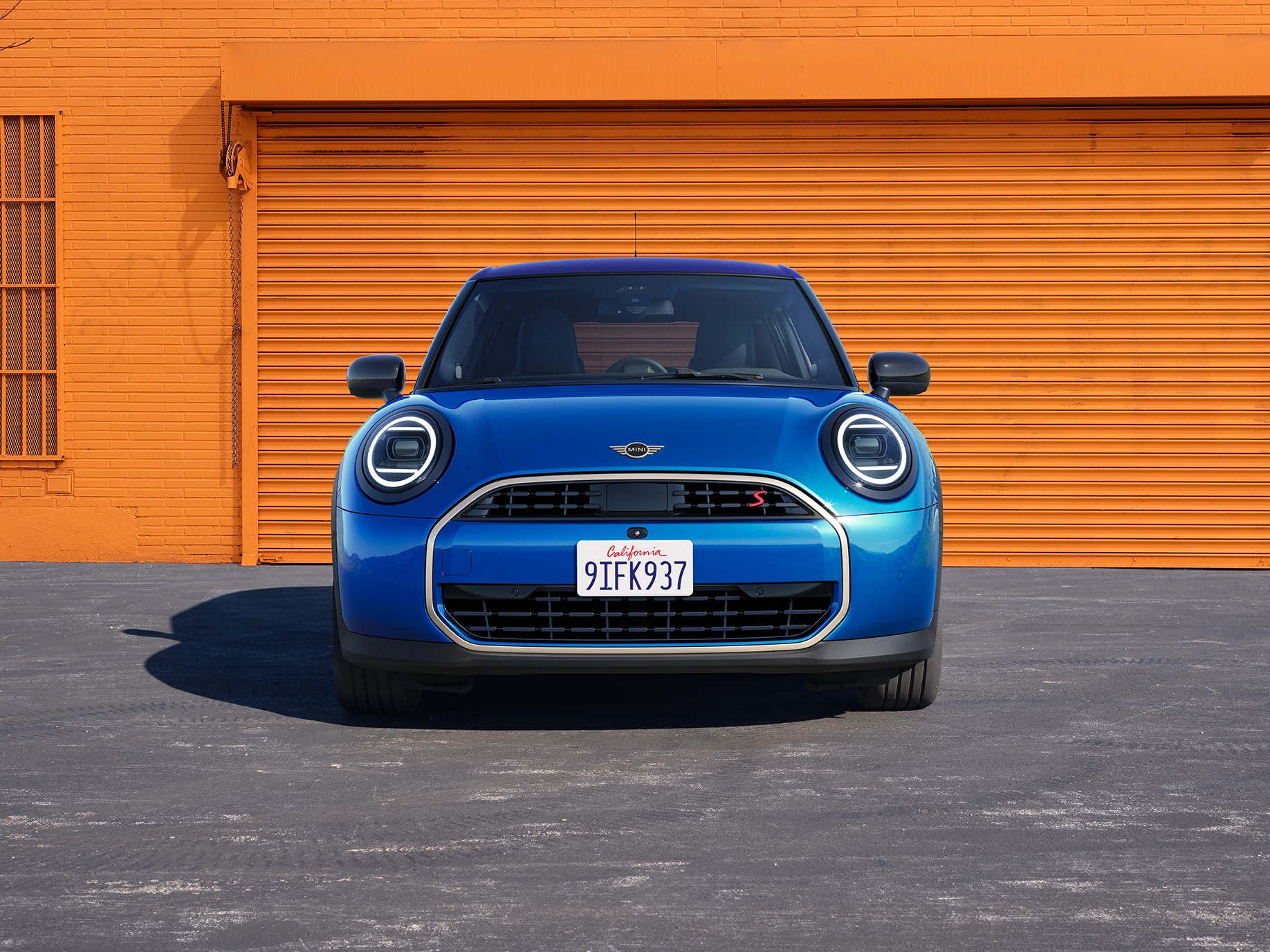 Vista frontal del MINI Cooper 5 puertas en Icy Sunshine Blue y con techo multitono azul.