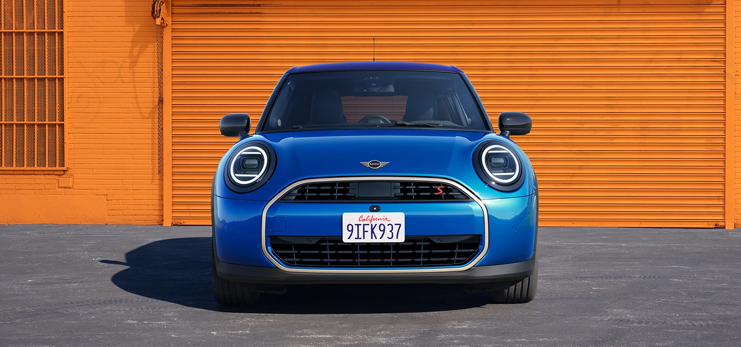 Vista frontal del MINI Cooper 5 puertas en Icy Sunshine Blue y con techo multitono azul.