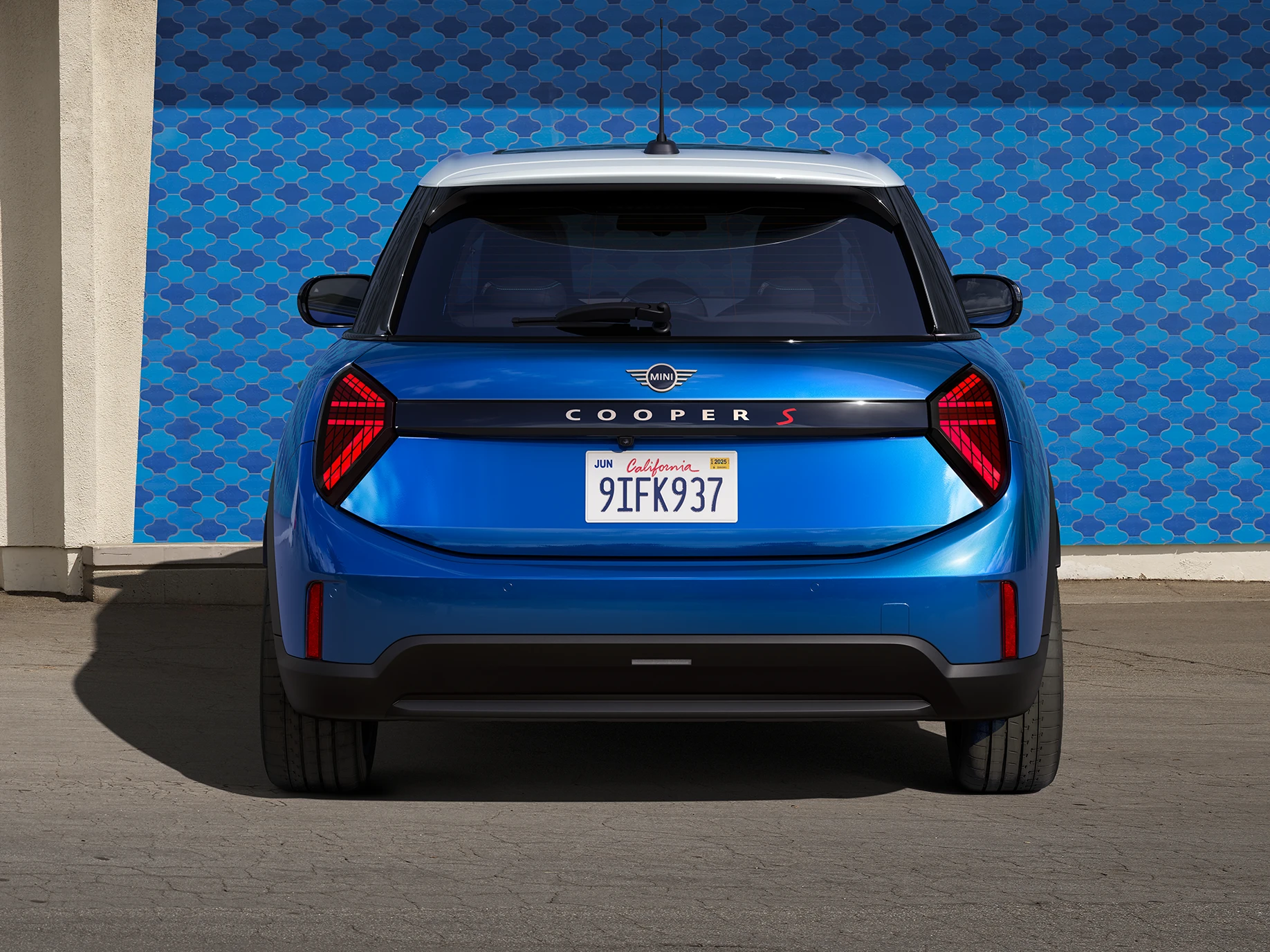 Vista trasera del MINI Cooper 5 puertas en Icy Sunshine Blue con techo Multitone azul.
