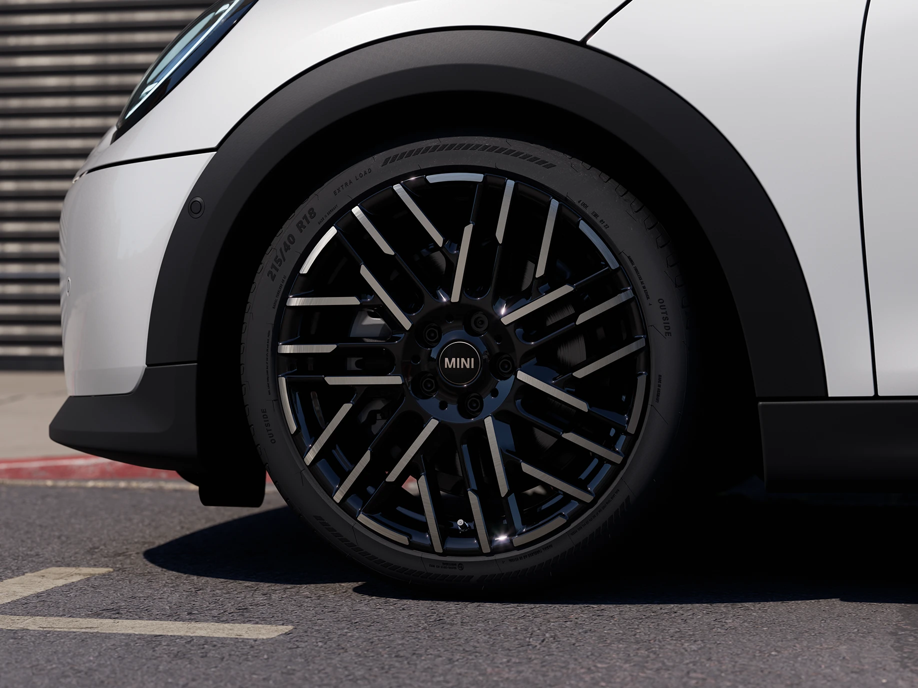 Primer plano del MINI Cooper 5 puertas en Nanuq White con llantas bitono Night Flash.