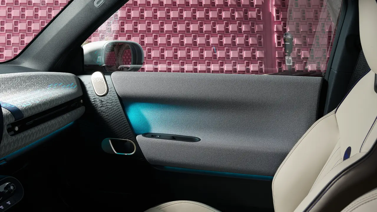 Vista interior de la puerta de un MINI Cooper 100 % eléctrico con iluminación ambiental