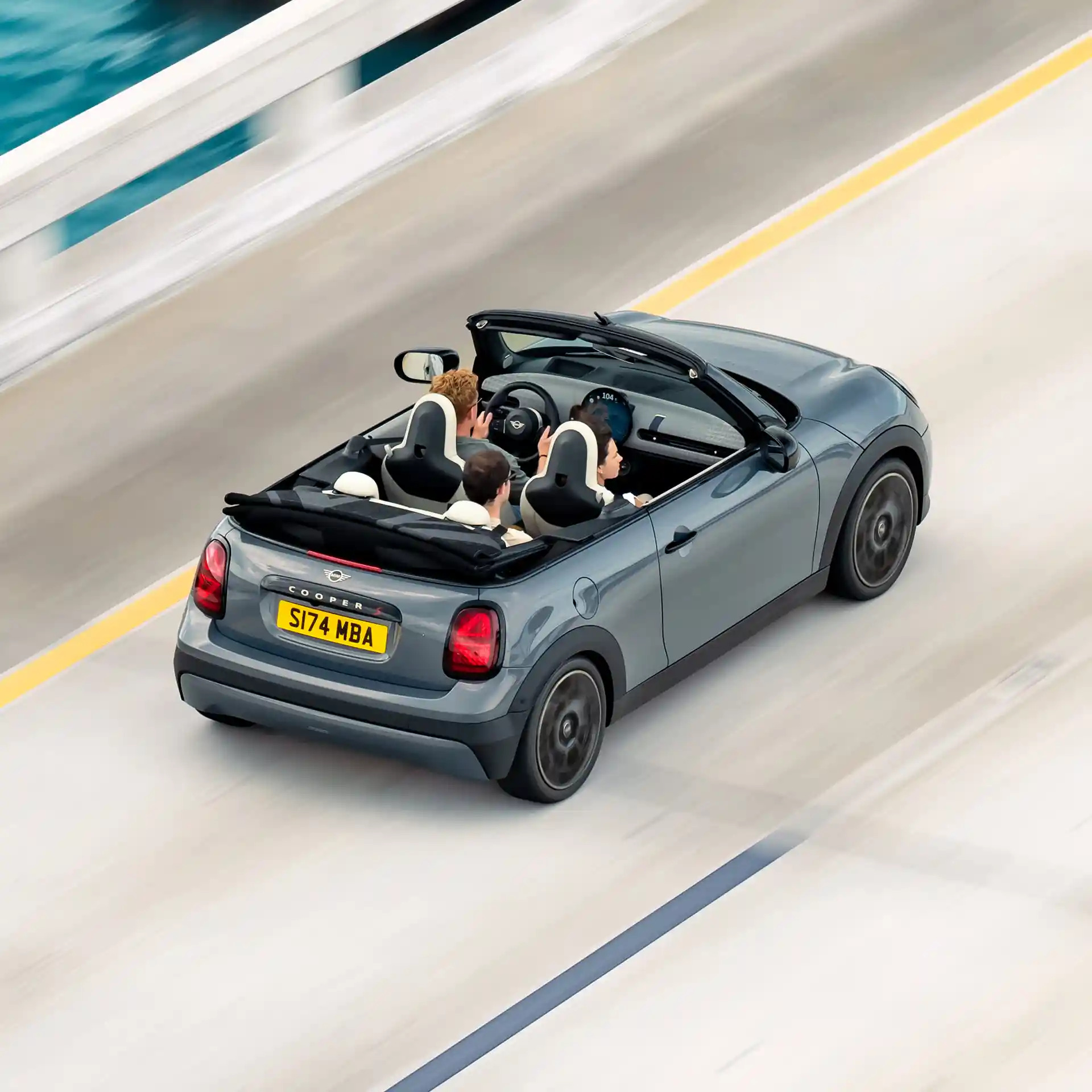 Vista superior trasera de un MINI Cooper Cabrio conduciendo por la calle