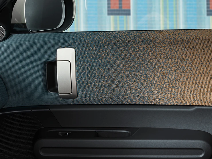 Vista detallada del diseño interior del MINI Countryman 100 % eléctrico, centrado en la puerta y el salpicadero.