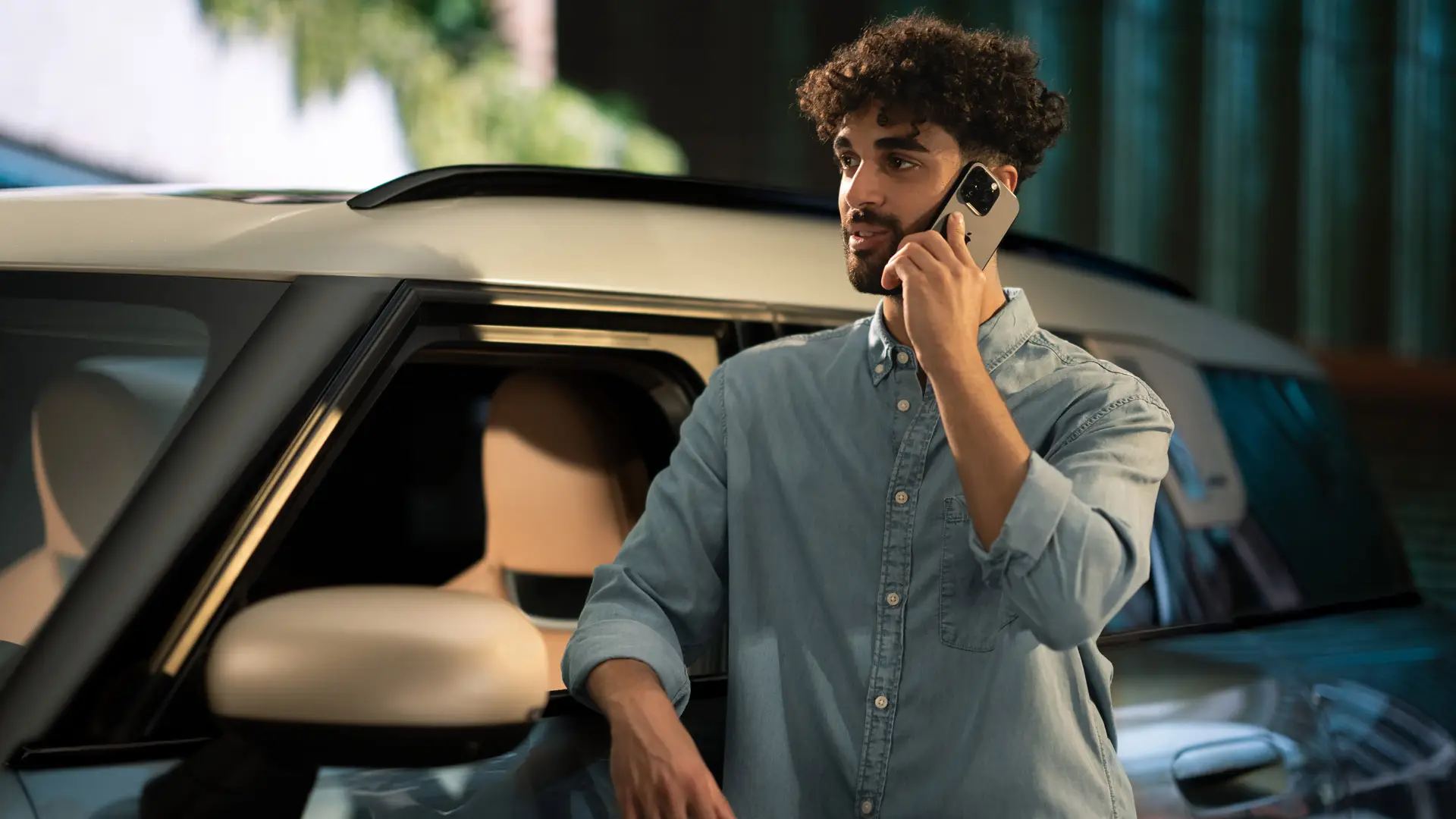 MINI Proactive Care: un hombre está de pie junto a su MINI hablando por teléfono con un asesor del centro de servicio.