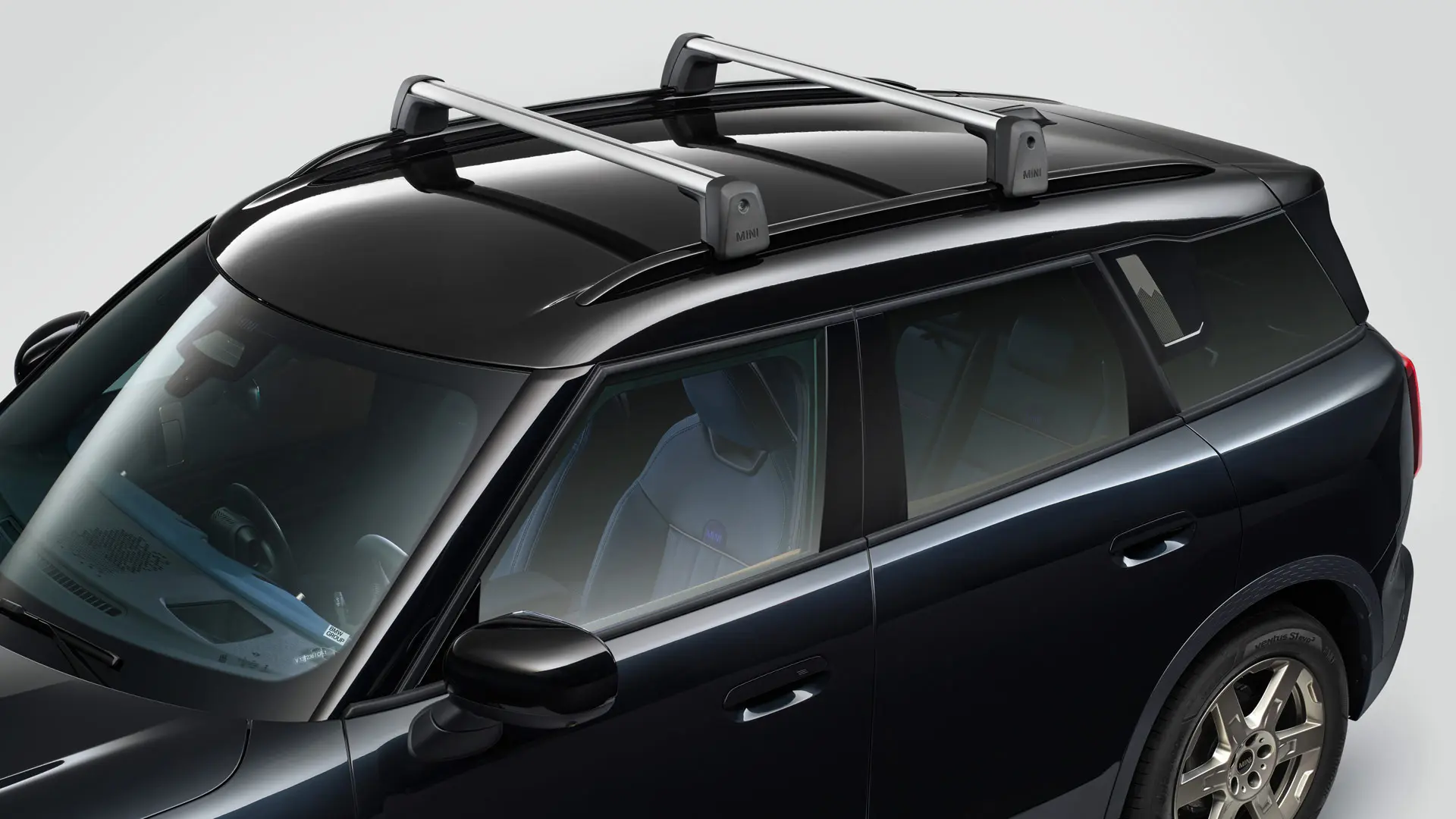 MINI Countryman Cooper en Midnight Black con barras de techo MINI (vista frontal-lateral).
