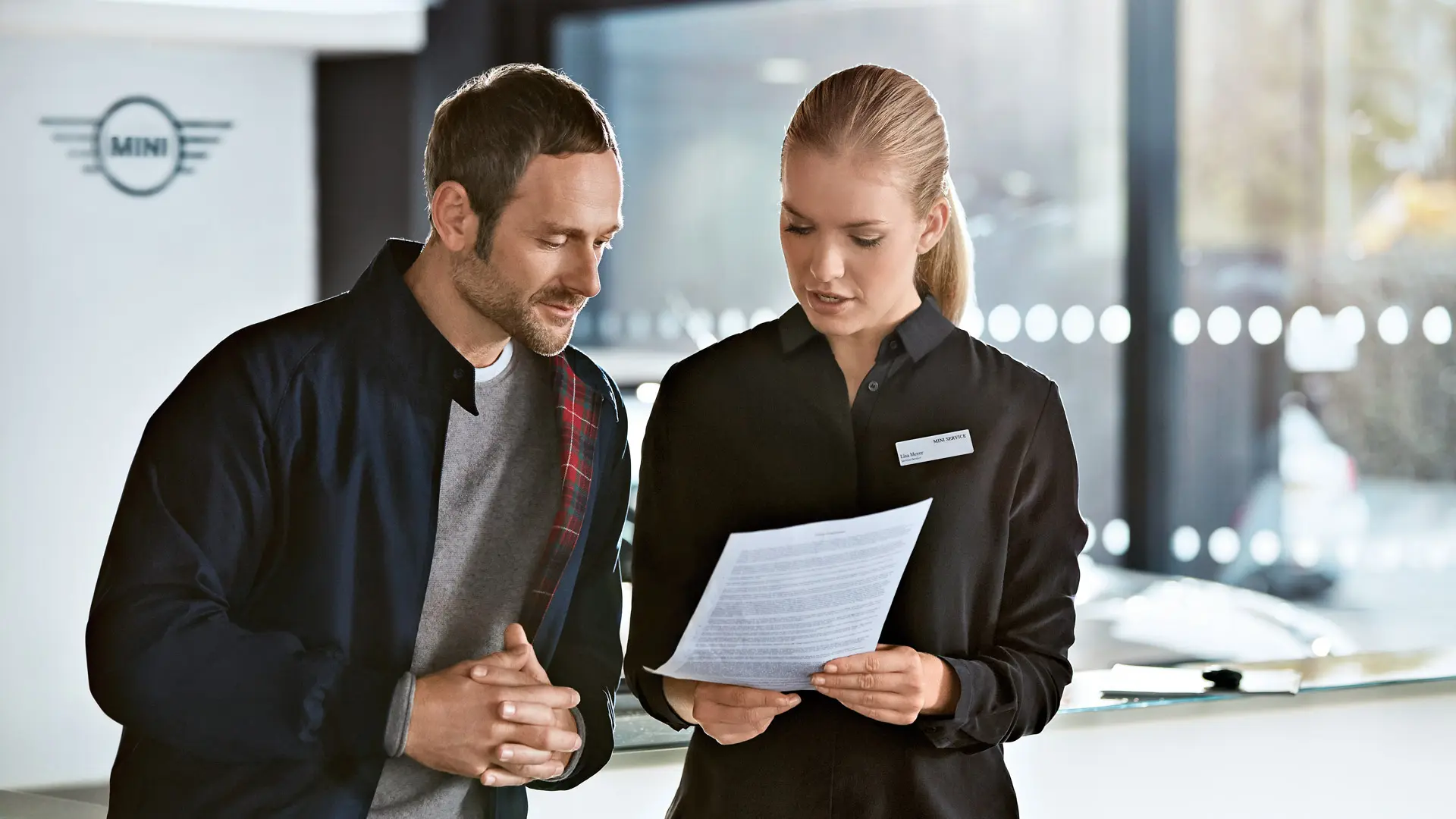 Un asesor del servicio técnico de MINI comenta al cliente los paquetes de mantenimiento en el MINI Centre.