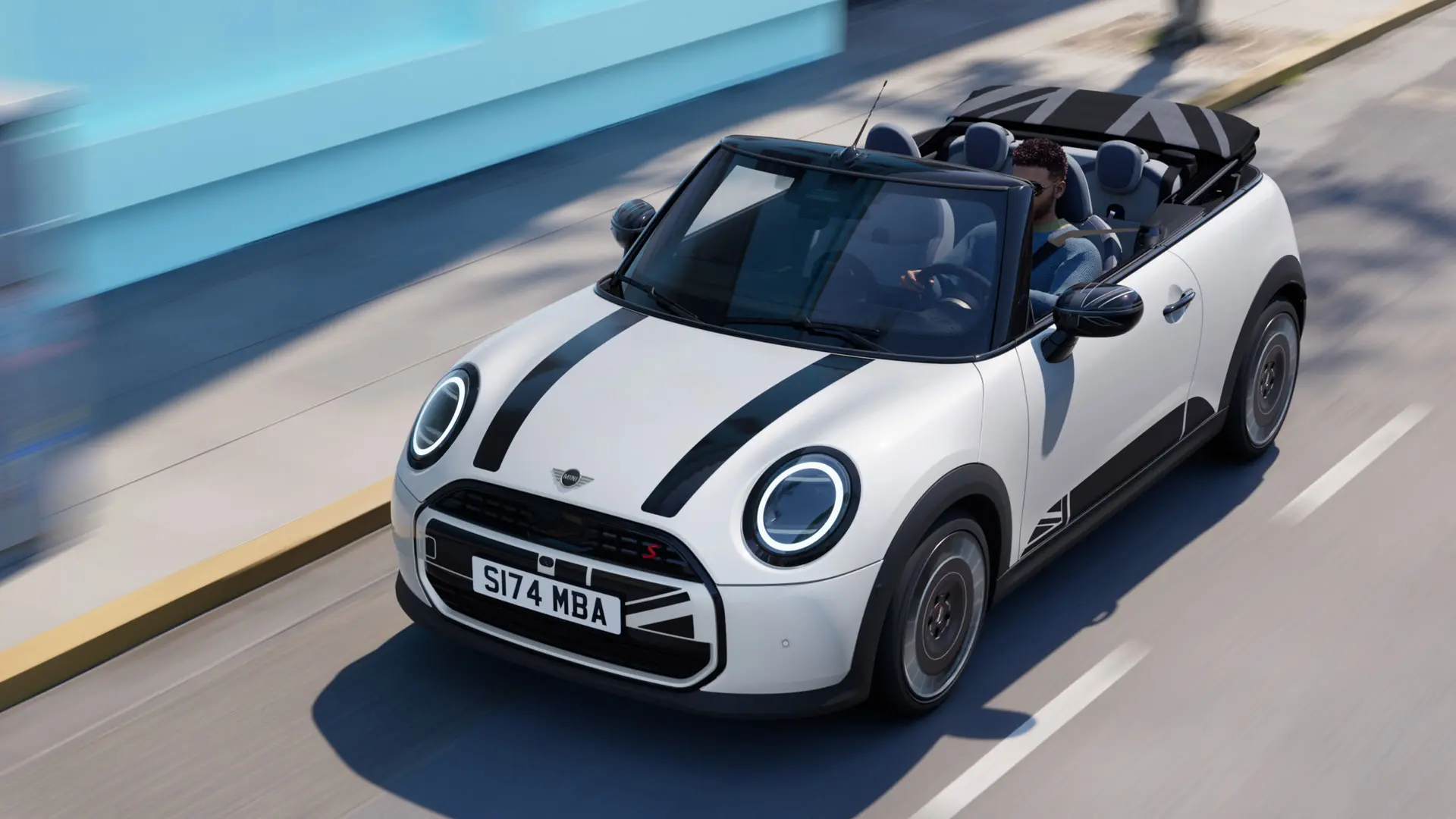 Fotografía aérea del MINI Cabrio en Nanuq White con adhesivos en el capó MINI Heritage en negro. 