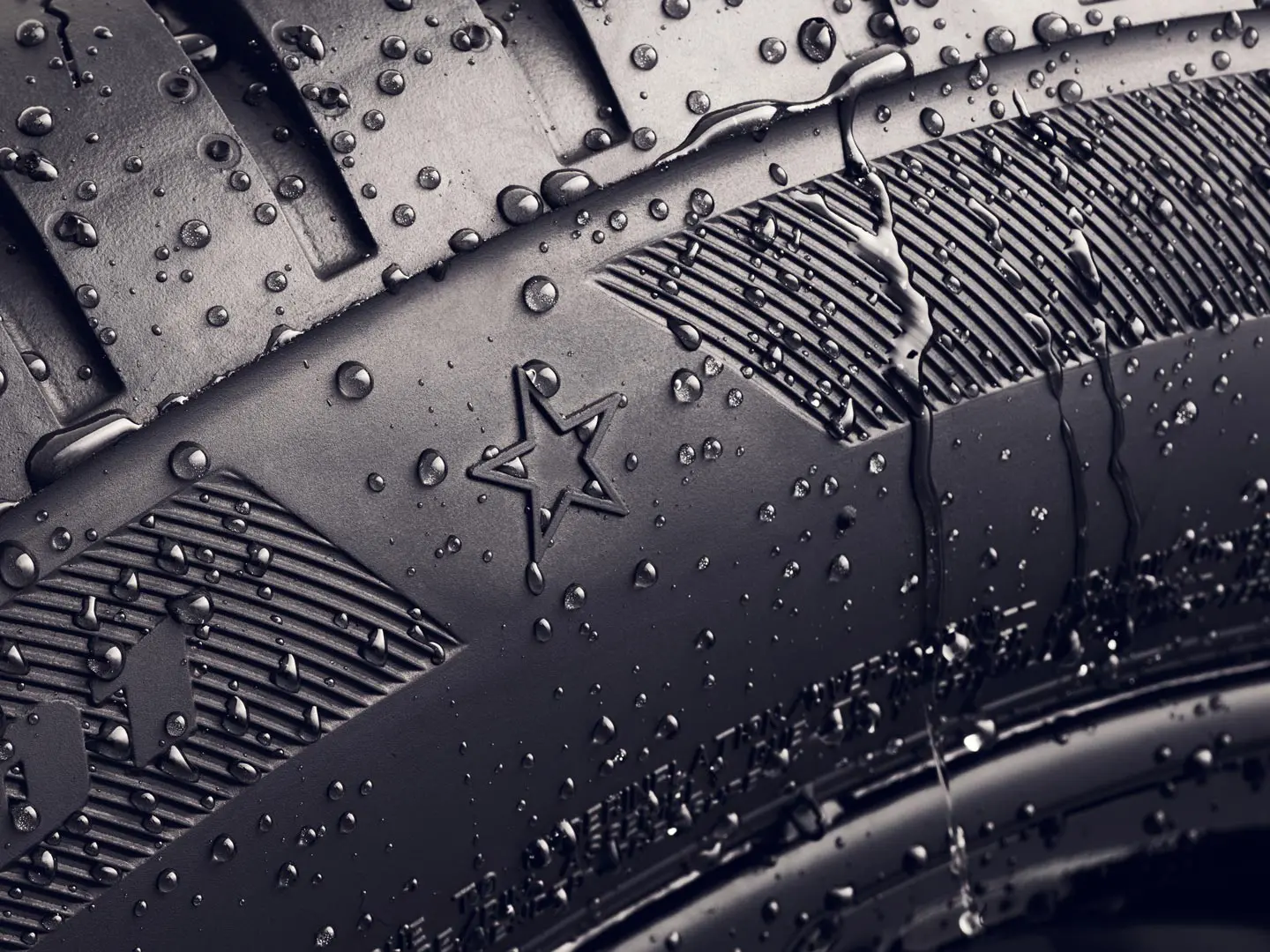 Primer plano del flanco de un neumático que muestra el símbolo de la estrella, que indica que está homologado para un rendimiento óptimo en vehículos MINI. 