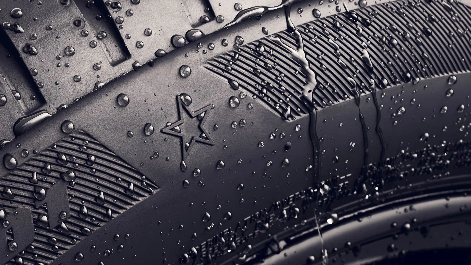 Primer plano del flanco de un neumático que muestra el símbolo de la estrella, que indica que está homologado para un rendimiento óptimo en vehículos MINI. 