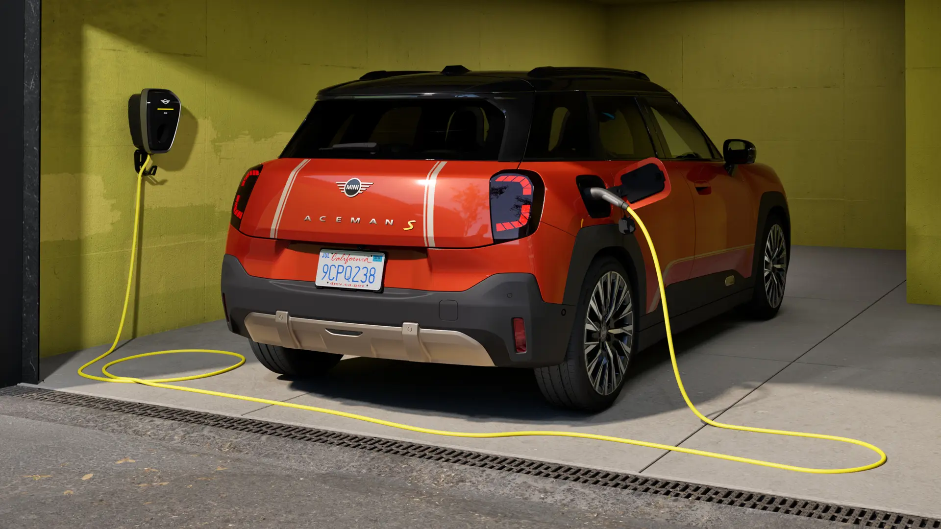 MINI Aceman S eléctrico cargando conectado a un MINI Wallbox Plus, vista trasera, aparcado en un garaje.