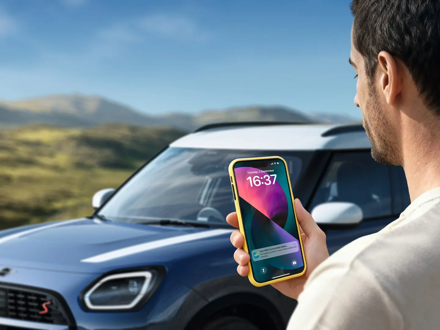 El conductor de un MINI Countryman utiliza la MINI App para contactar con la asistencia en carretera MINI. 