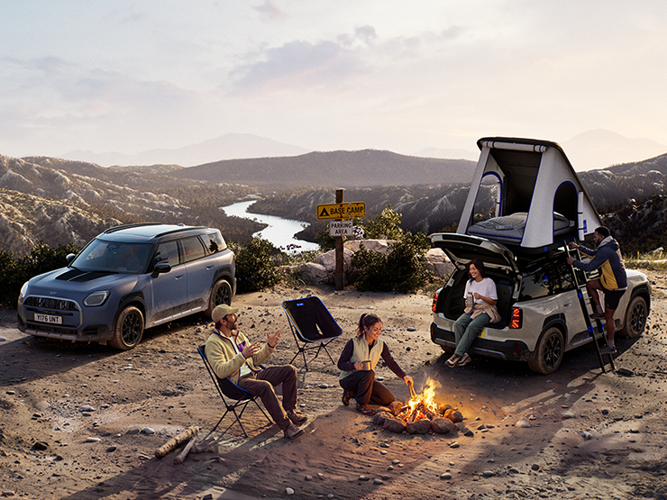 Imagen de dos vehículos MINI Countryman Untamed Edition en una montaña al atardecer.