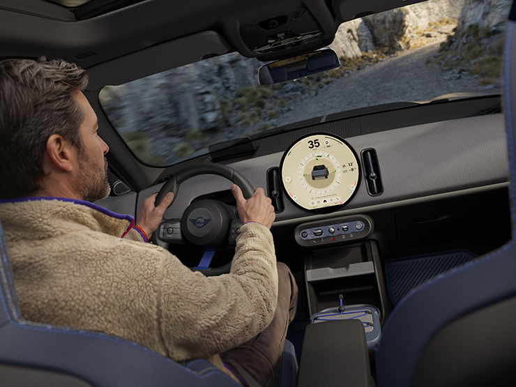 Imagen de dos personas conduciendo en el MINI Countryman Untamed Edition con el Trail Mode activado.