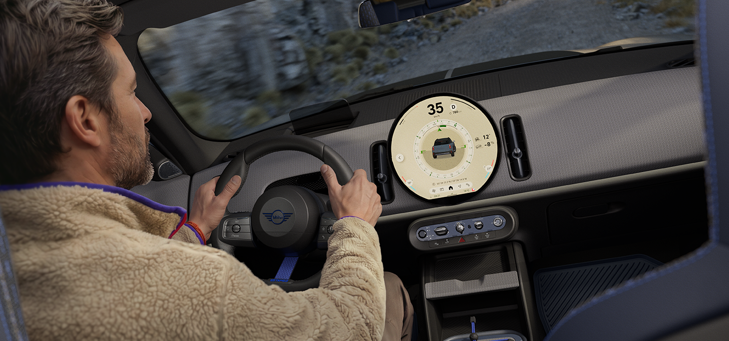Imagen de dos personas conduciendo en el MINI Countryman Untamed Edition con el Trail Mode activado.