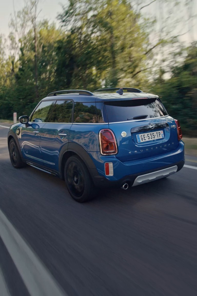 Die MINI Highlands Edition in Dreiviertelansicht von hinten auf der Strasse fahrend